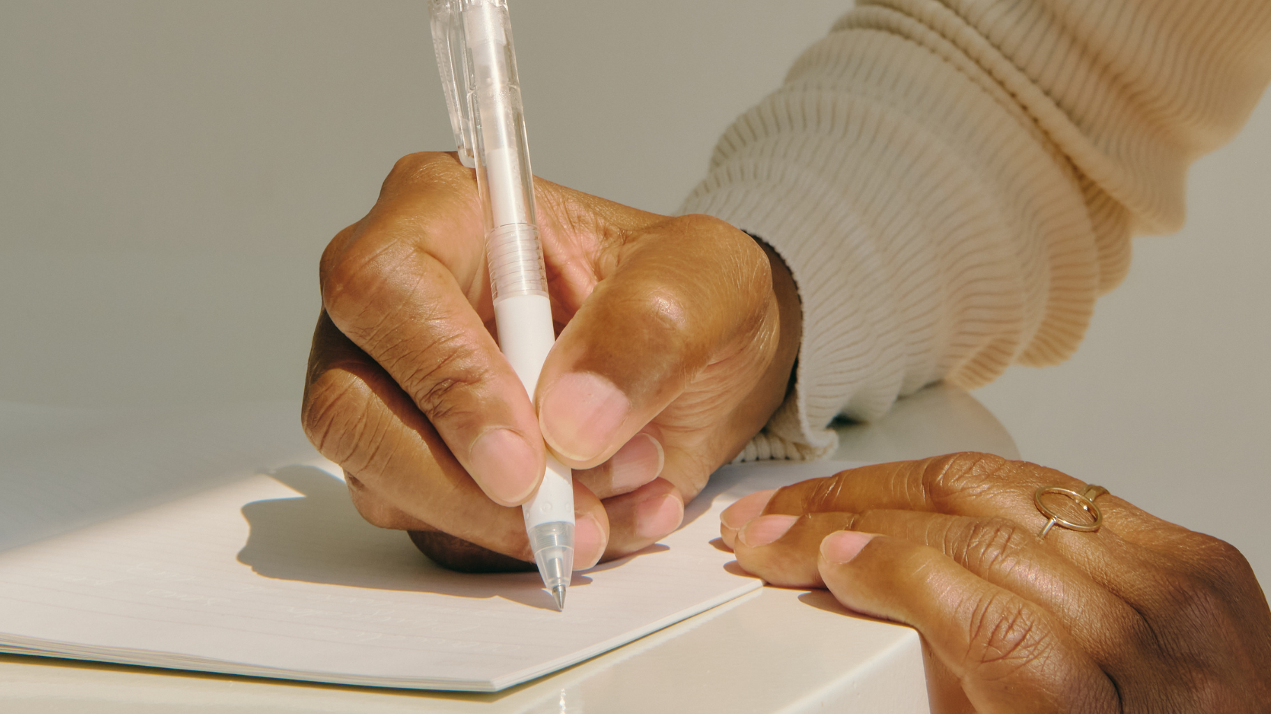 Woman writing in a recycled paper journal as part of a mindful morning routine