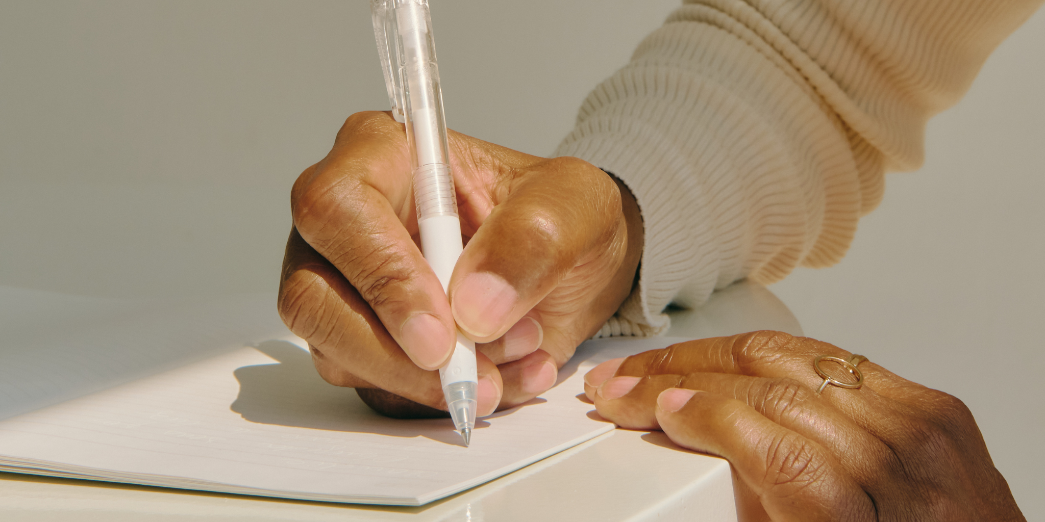 Woman writing in a recycled paper journal as part of a mindful morning routine